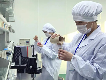 Cleanroom staff checking material assay in factory laboratory