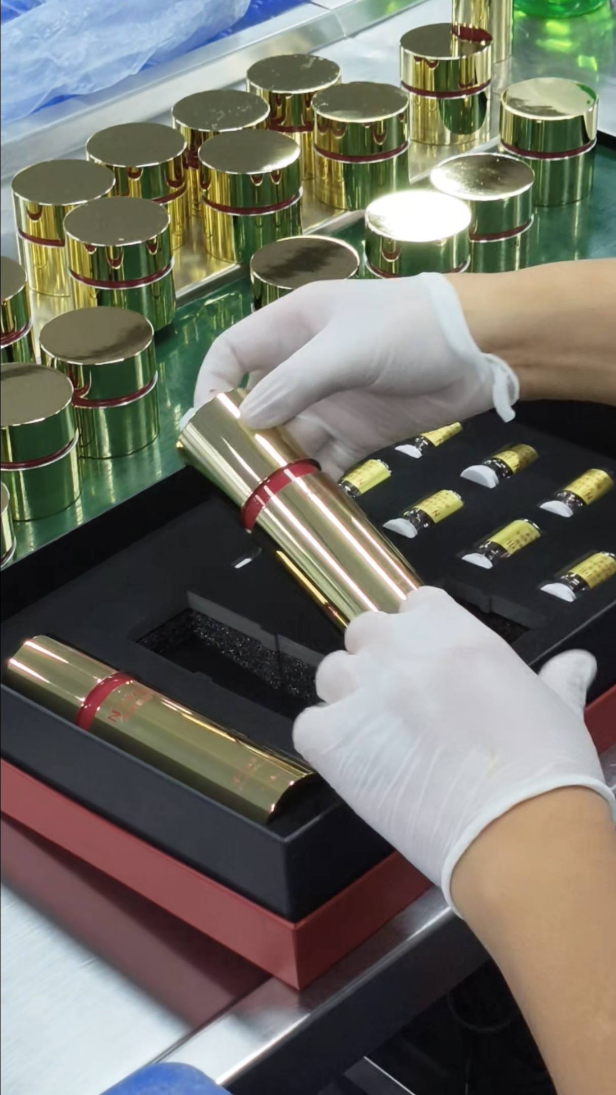 Gloved hands placing a cosmetic container into a fitted black insert in an open presentation box
